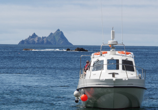 Skellig Falcon on approach to the Glen Pier with fenders out and the Skelligs in the background